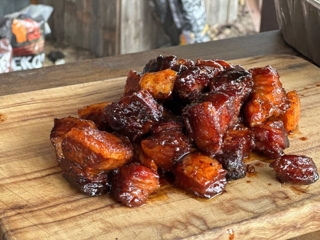 Smoked pork belly cubes on a cutting board.