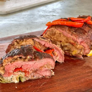 A piece of meat with peppers on top