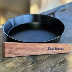 Black cast iron skillet with wooden handle.