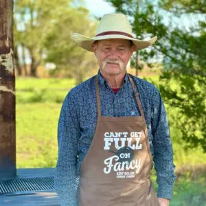 Man wearing a cowboy hat and apron.