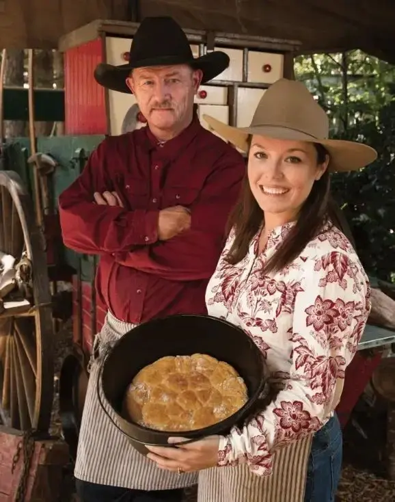 Couple in cowboy hats holding baked bread.