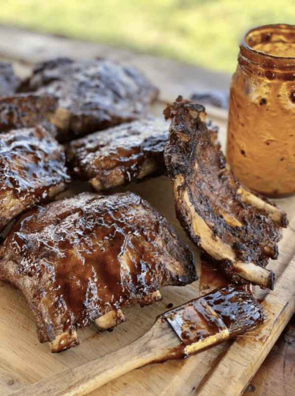 Glazed BBQ ribs on a wooden board.