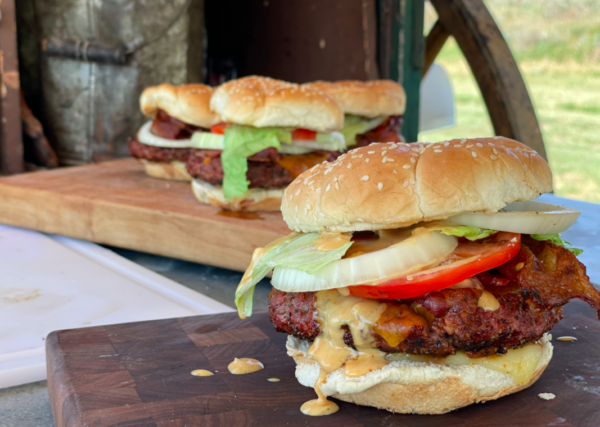 Close-up of a bacon cheeseburger with lettuce.