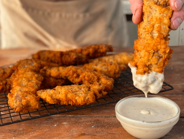 Fried chicken strips dipped in white sauce.