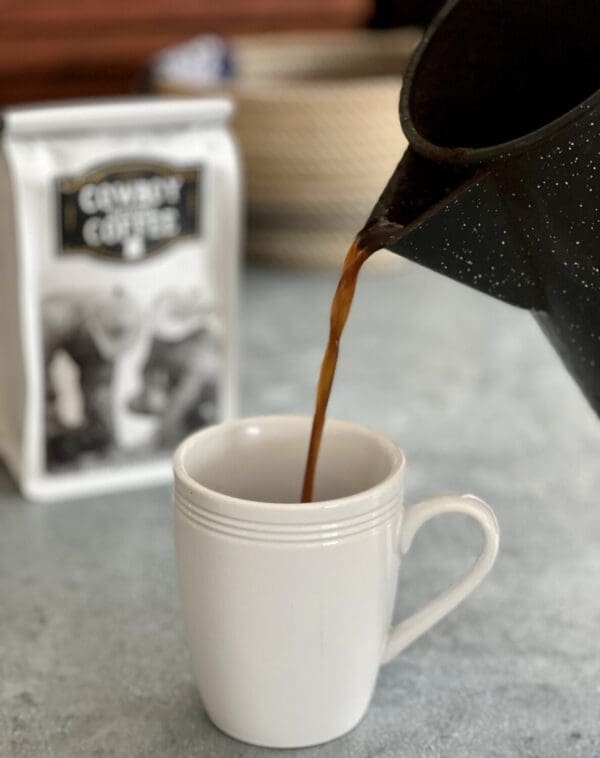 Coffee pouring into white mug.