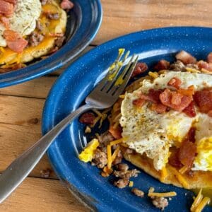 A plate of food with eggs, ham and beans.