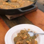 A bowl of food on top of a wooden table.