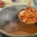 A bowl of beans and some gravy in it