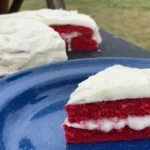 A red velvet cake with white frosting on top of it.