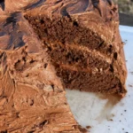 A chocolate cake with three slices missing.