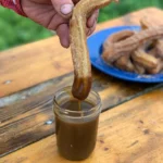 A person pouring syrup on some food