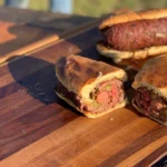 A close up of two sandwiches on a wooden table