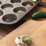 A muffin tin with some jalapenos in it