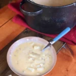 A bowl of soup on top of a table.