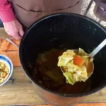 A bowl of soup with a spoon in it.