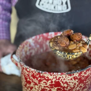 A pot of stew with sausage and beans.