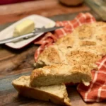 A piece of bread on top of a wooden table.