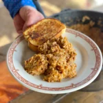 A person holding a plate with food on it.