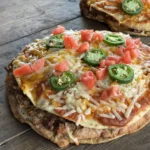 A pizza with cheese, tomatoes and jalapenos on it.