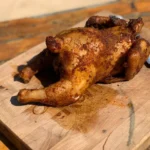 A chicken is sitting on the cutting board.