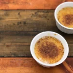 Two bowls of food on a wooden table.