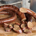 A bunch of sausage sitting on top of a table.