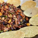 A plate of food with tortilla chips on the side.