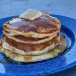 A stack of pancakes with syrup and butter on top.