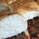 A close up of a sandwich with meat and tomato