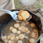 A pan of fried food being cooked in the open.