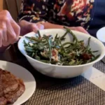 A person sitting at the table with some food.