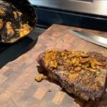 A piece of meat on top of a cutting board.