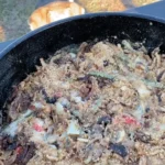 A pan of food with meat and vegetables in it.