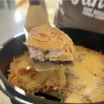 A pan of food with some kind of meat and cheese.