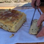 A person cutting food on top of a paper.