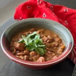 A bowl of chili with cilantro on top.