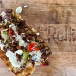 A close up of a piece of food on top of a cutting board.