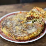 A pizza sitting on top of a white plate.