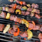 A grill with some meat and vegetables on it