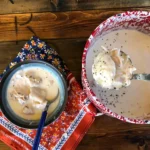 A bowl of food and a spoon on the table.