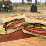 A sandwich cut in half on top of a wooden table.