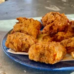 A plate of fried food on top of a table.