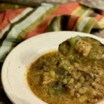 A bowl of soup with meat and vegetables.