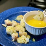 A blue plate with food on it and a bowl of egg