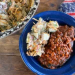 A bowl of beans and coleslaw on the side.