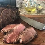 A close up of a piece of meat on top of a cutting board.