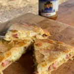 A piece of pizza sitting on top of a wooden cutting board.