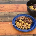 A blue plate of food on top of a wooden table.