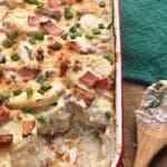 A casserole dish with potatoes, ham and cheese.