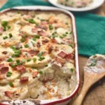 A casserole dish with potatoes, ham and cheese.